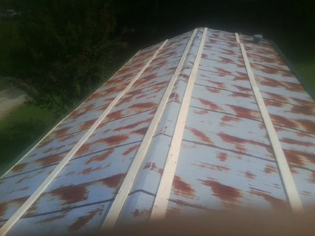 Rusted metal roof panels with new wood purlins before replacement — Storm Damage Roof Repair in South Beach by Roofing Brothers