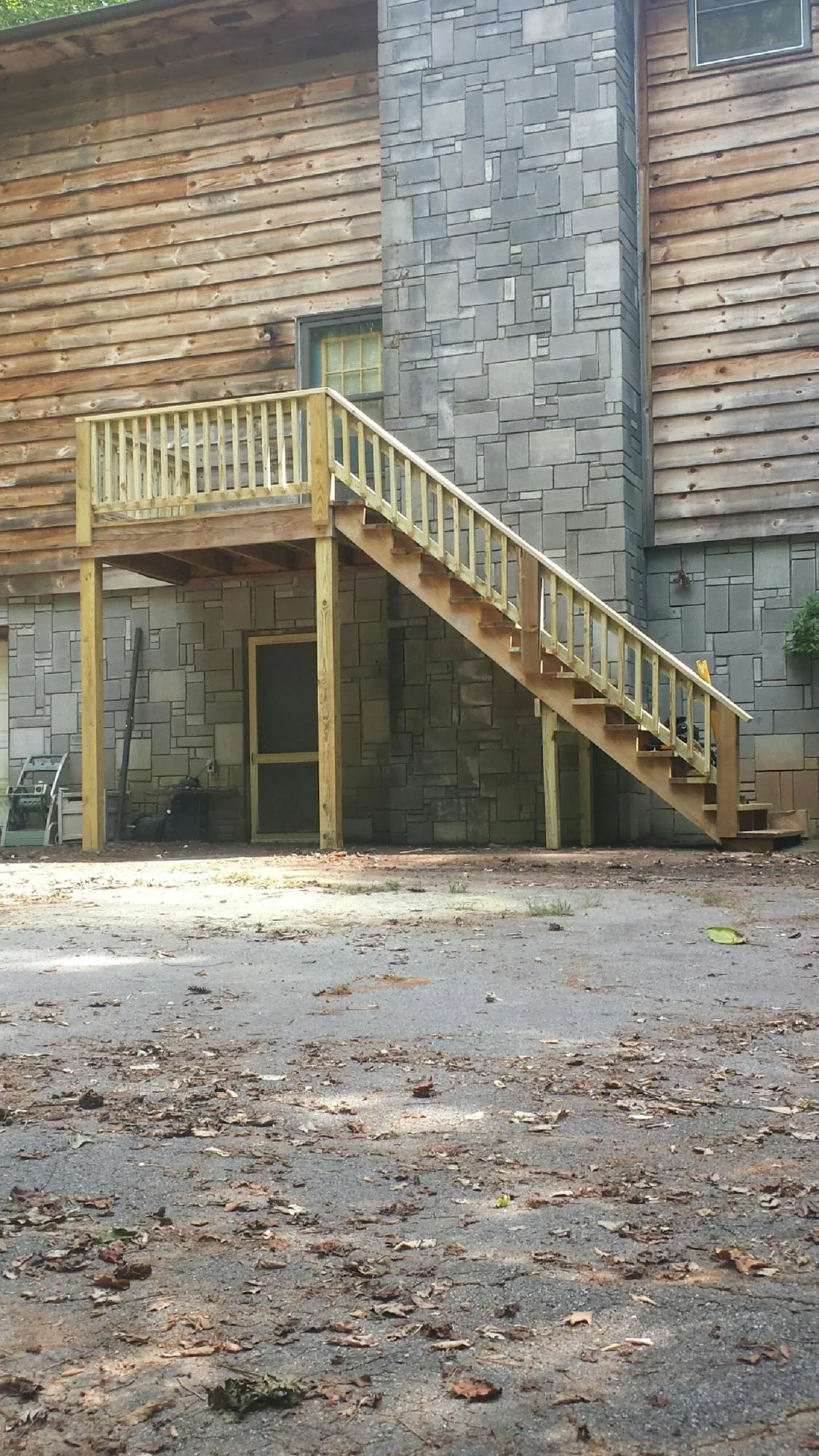 New pressure treated deck and stair landing on a log home in South Beach